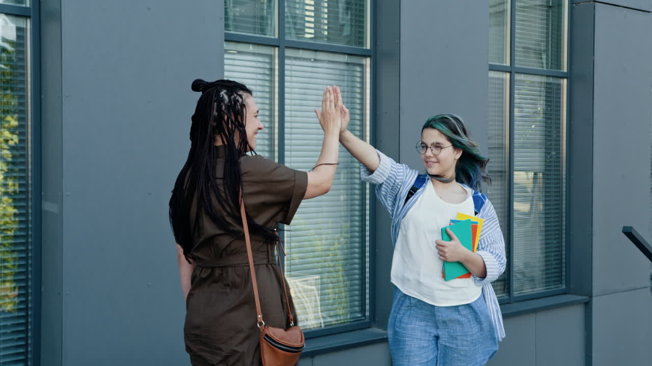 dos estudiantes dando los cinco.
