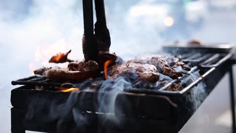 slow motion shot of an asian street vendor cooking ayam bakar on a smoky grill