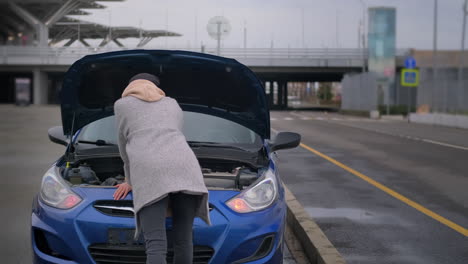 mujer con un coche averiado en el aeropuerto