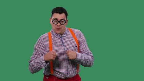 un retrato de un hombre bailando y cantando junto a la música. un hombre con gafas con lentes gruesas, en una camisa a cuadros con tirantes naranjas en el estudio en una pantalla verde. cámara lenta. cerca