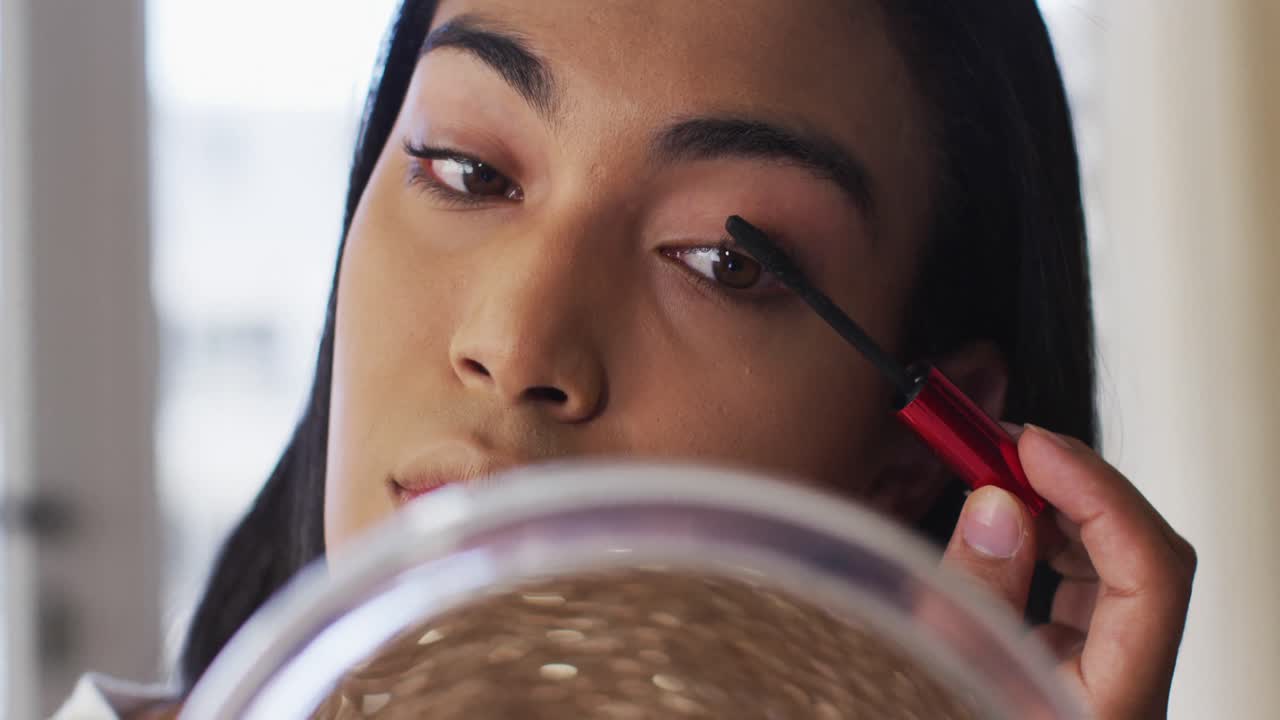 vlogger de género fluido de raza mixta grabando un vlog de maquillaje en casa