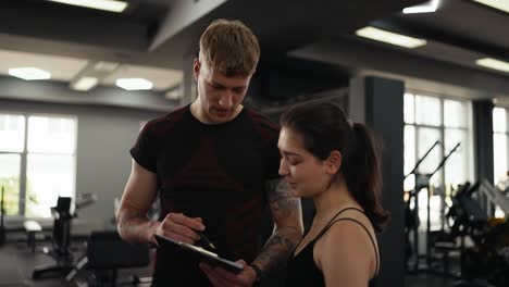 a personal trainer is working with a client in a gym