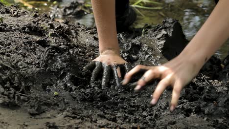 woman's hands in a mud during extreme run