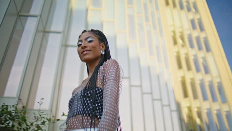 city fashionista walking street low angle. dark skin lady touching braids posing