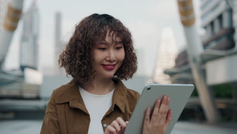 young woman using tablet in city