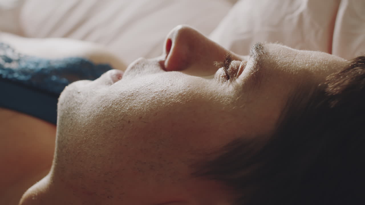 joven transexual soñoliento despertando por la mañana