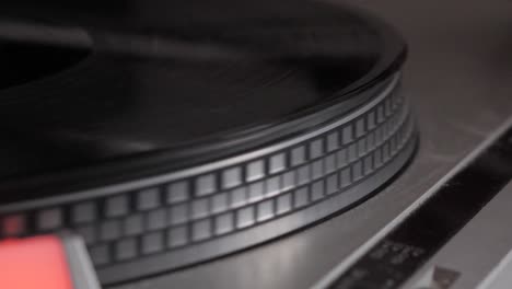Slow-motion-of-black-vinyl-record-spinning-up-from-start-on-antique-turntable