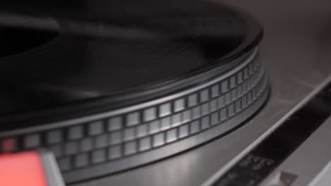 slow motion of black vinyl record spinning up from start on antique turntable