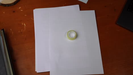la película adhesiva se coloca sobre un papel sobre una mesa de madera y se retira de nuevo