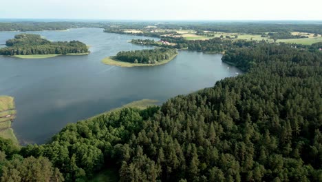 Bewaldete-Inselchen-Im-Blauen-Wasser-Des-Sees-Und-Ein-Wald-Am-Ufer