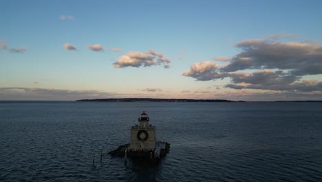 an aerial view of the huntington harbor lighthouse on long island, ny at sunset, with a christmas wreath