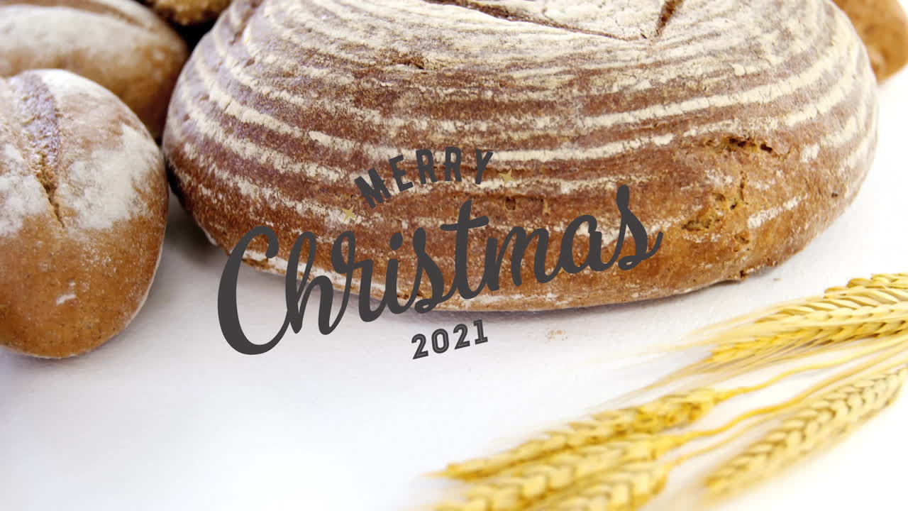Merry Christmas 2021 text on bread with wheat on white background