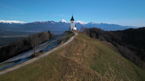 forward drone shot above mountain chapel in slovenian alps