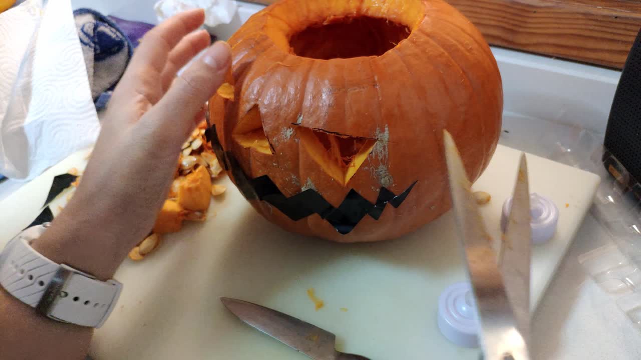 pumking siendo tallado para hacer un jack-o'-lantern para halloween