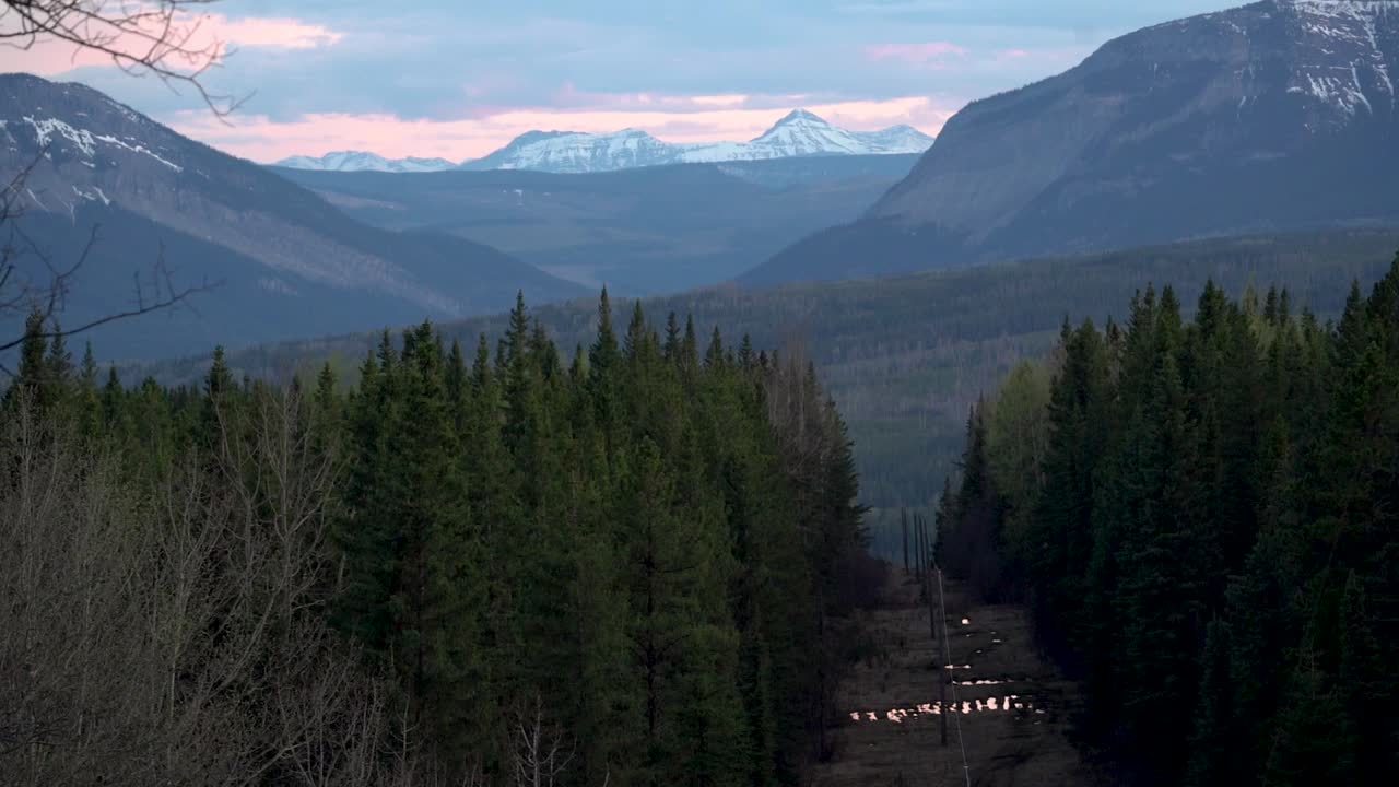 Carrellata verticale lenta che rivela le Montagne Rocciose Canadesi durante il tramonto.