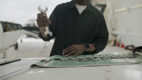 mechanic selecting wrench from tool roll for aircraft maintenance