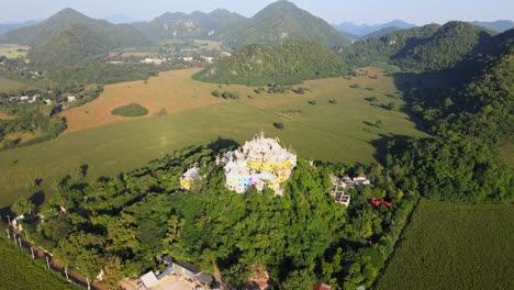 top down: drone flies forward to a temple on a hill