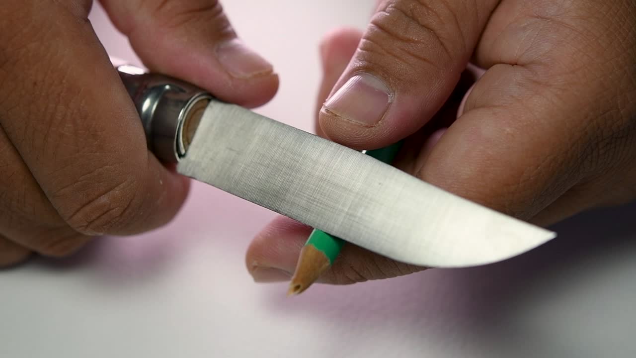 imágenes de manos afilando lentamente un lápiz y algunos lápices de colores con un cuchillo afilado
