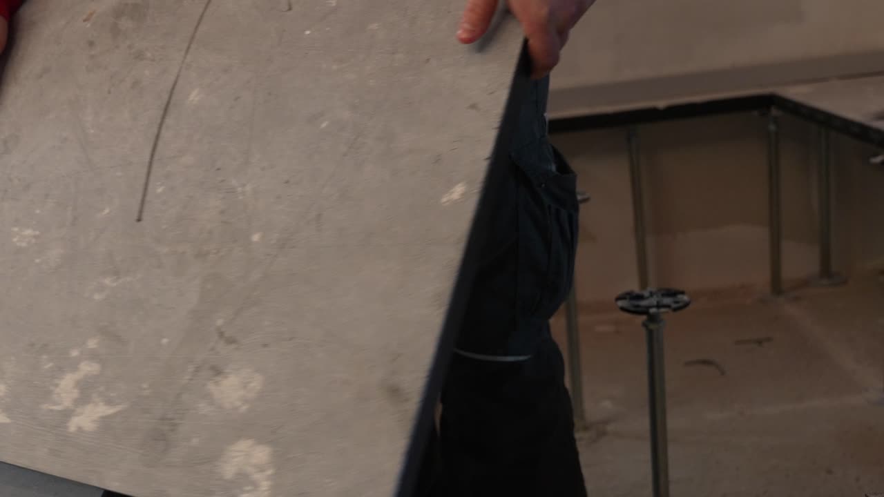 trabajador de cuello azul del sitio de construcción termina de colocar placas de piso de hormigón