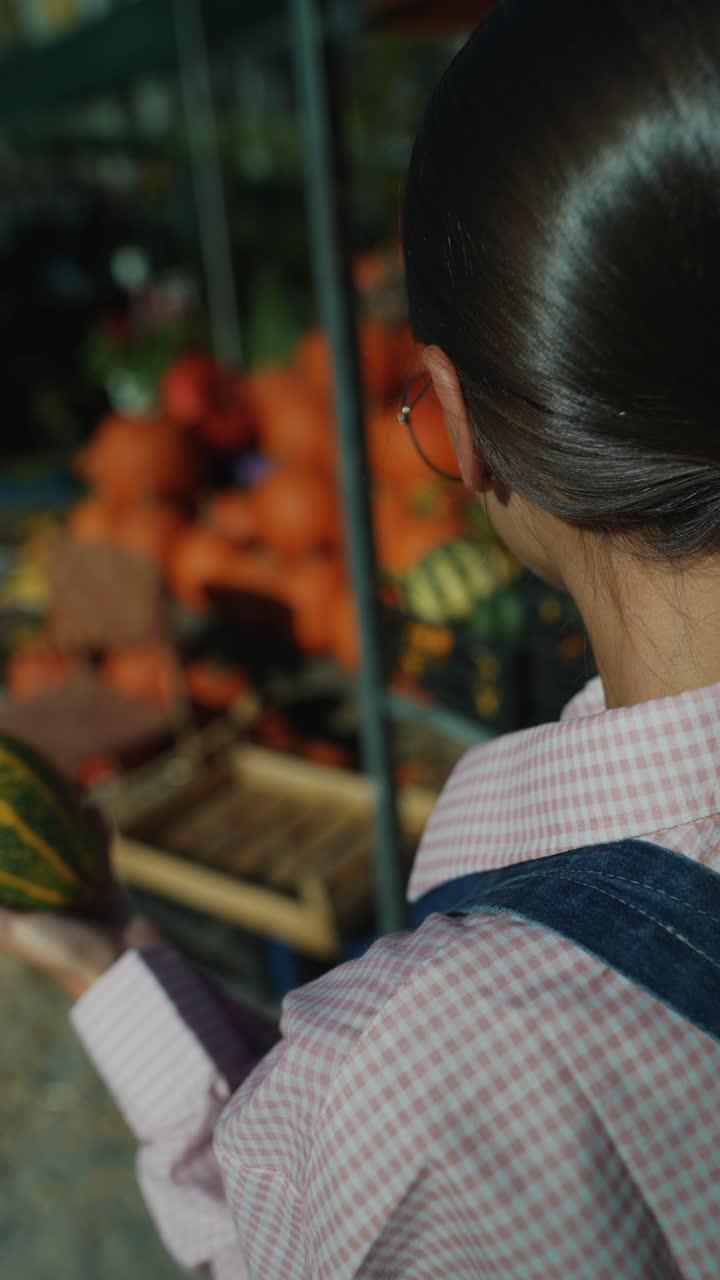 mujer comprando calabazas en un mercado de otoño