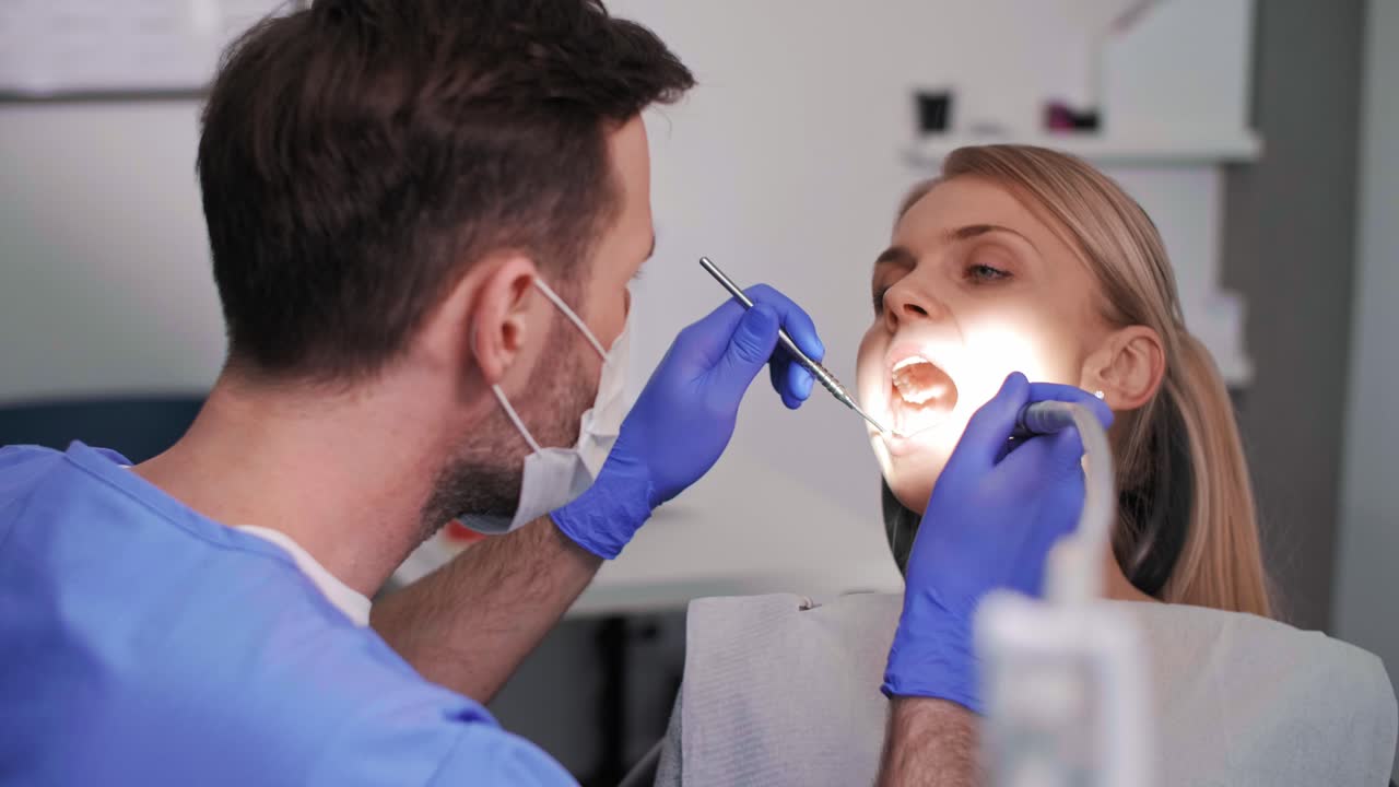 dentista usando broca dental e espelho dental