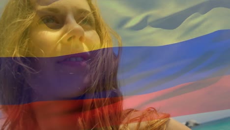 Animation-of-flag-of-colombia-over-caucasian-woman-at-beach