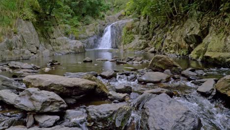 waterfall flowing into rocky stream - freshwater creek with crystal cascades in the background