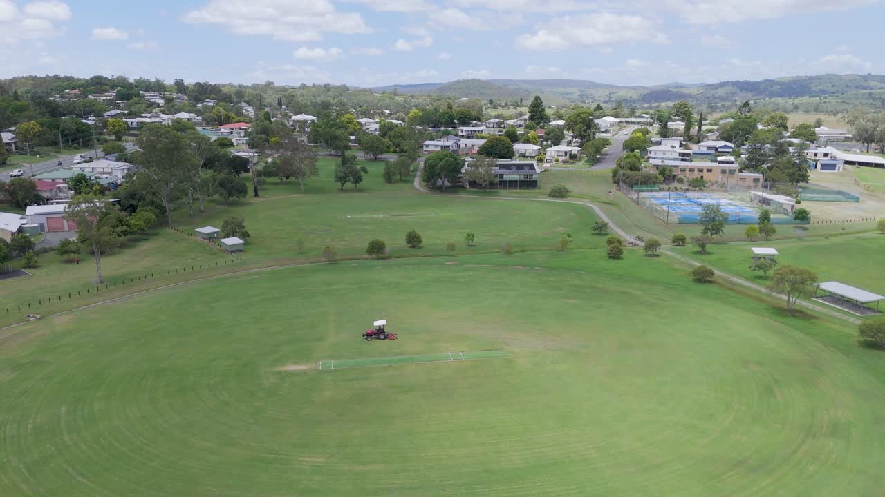 트랙터 가 큰 초록색 스포츠 경기장을 고 있다