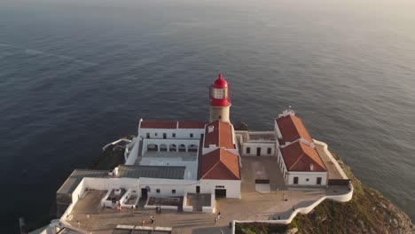 aerial drone flying over cliffside cabo de san vicente cape saint vincent lighthouse in sagres algarve portugal