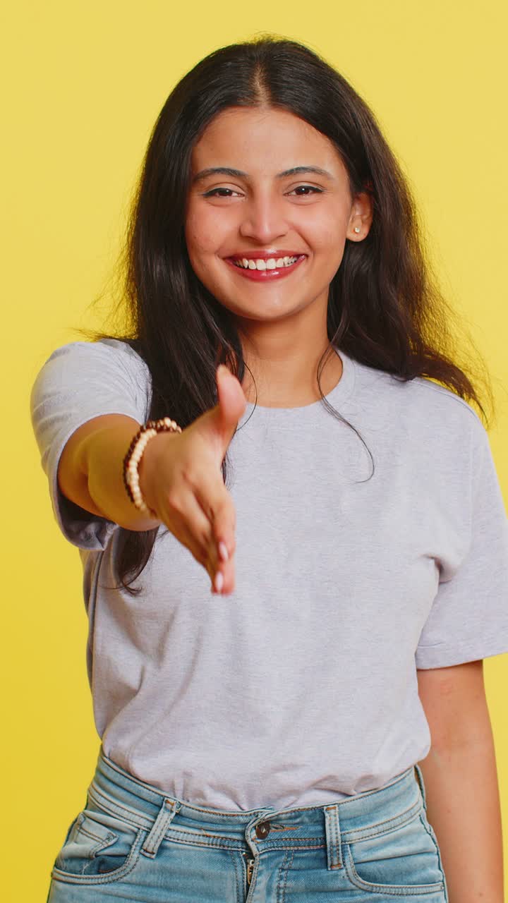Indian young woman outstretching hand to camera offering handshake greeting invitation welcoming