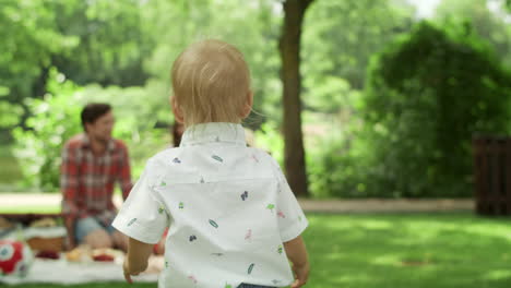 cheerful toddler running towards sister in the park