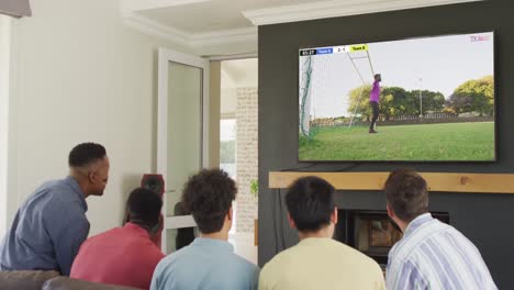 Video-of-diverse-friends-sitting-on-sofa-and-watching-football-on-television-at-home