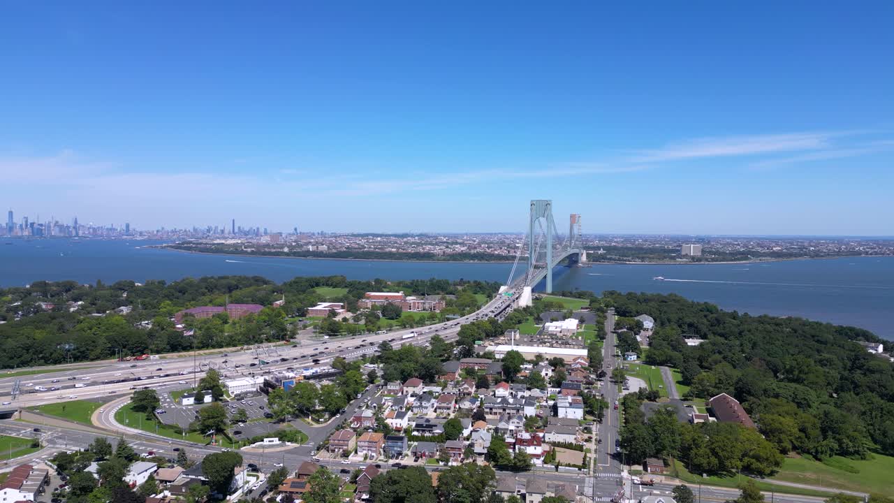 Stunning aerial view of Staten Island and the Verrazzano-Narrows Bridge with a clear skyline, waterfront, and residential neighborhoods under a bright blue sky