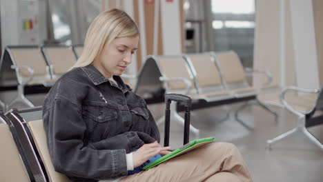 woman using tablet in airport waiting area