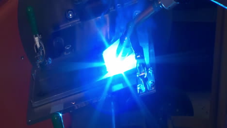 automated synchronized robotic arm welding operation, sparks flying during electric welded in high-tech industrial facility setting with precision power