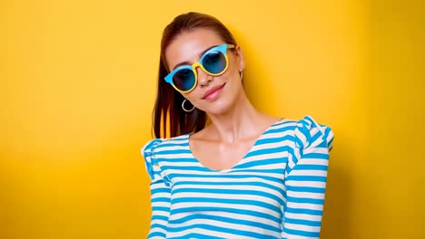 a woman wearing a blue and white striped shirt and sunglasses