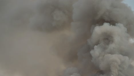 black smoke clouds and flames rise into the sky.