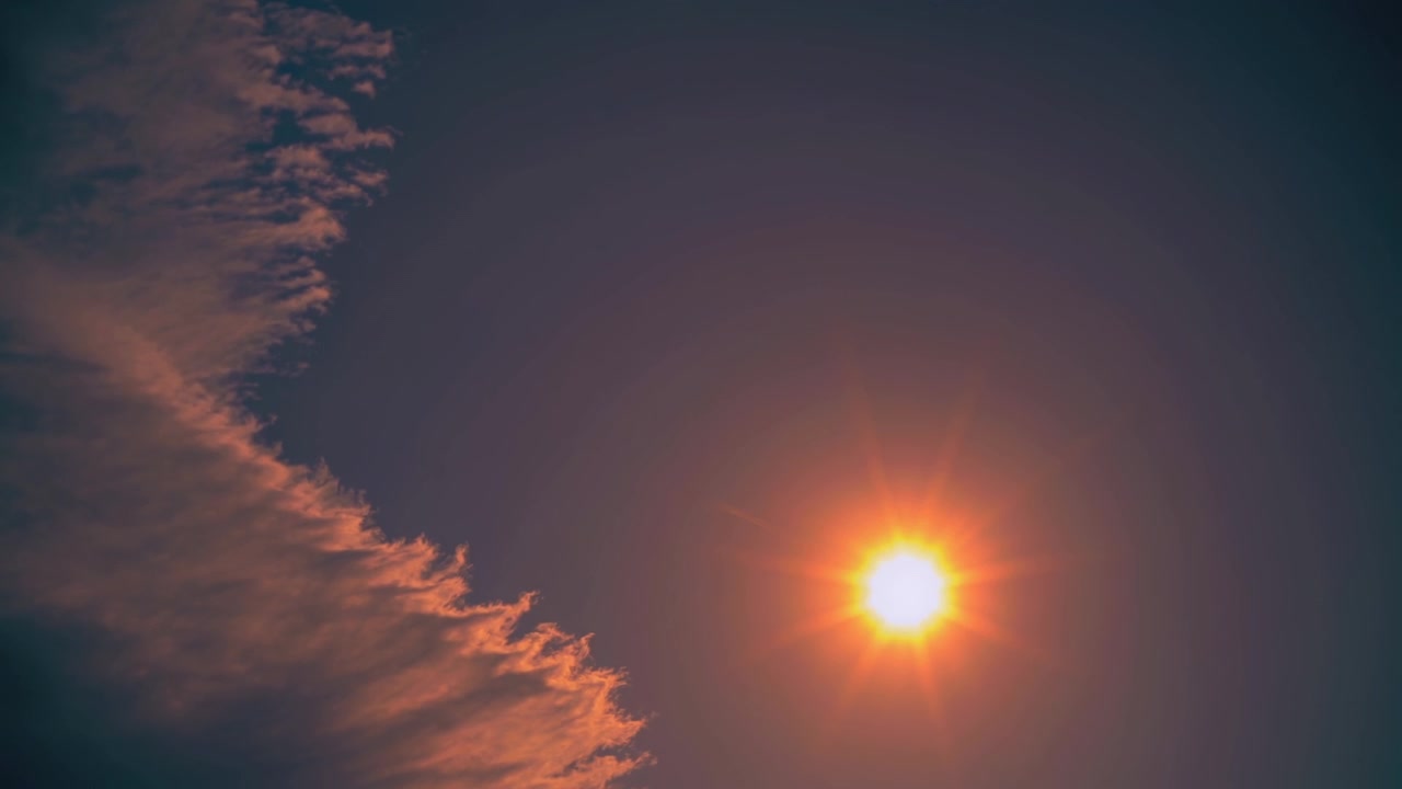 Strålende sol på en klar himmel med fjerlette skyer