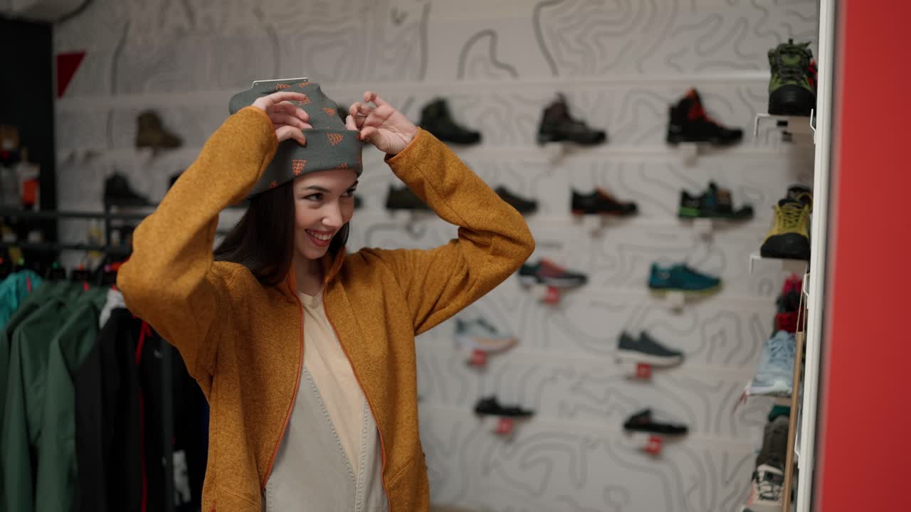 retrato de una mujer adulta probándose un nuevo y colorido sombrero de invierno en una tienda
