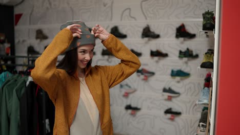 Portrait-of-a-adult-woman-trying-on-a-new-colorful-winter-hat-in-a-store