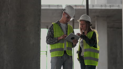 Engineers-or-architects-have-a-discussion-at-construction-site-looking-through-the-plan-of-construction.-contre-jour.-Engineers-or-architects-have-a-discussion