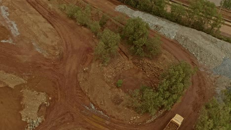 vista aérea baja de camiones volcadores que transportan toneladas de mineral rico en níquel alrededor de un sitio minero en taganito