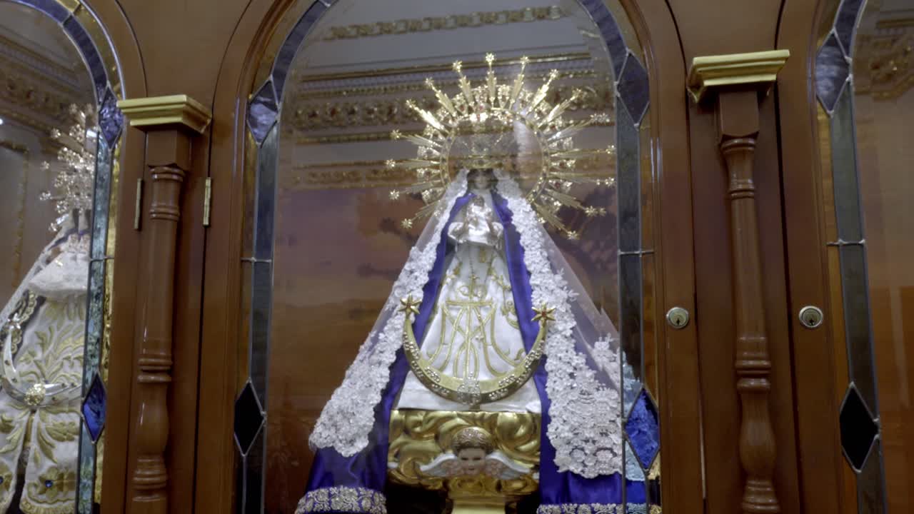 Statua religiosa della Vergine Maria all'interno di una chiesa cattolica decorata a Cholula Puebla, Messico, circondata da un'architettura d'altare sontuosa.