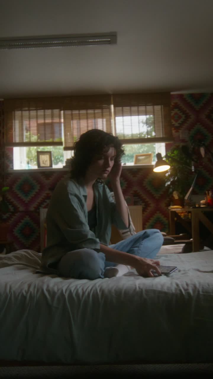 젊은 여성이 침실에서 휴식을 취하고 있습니다.