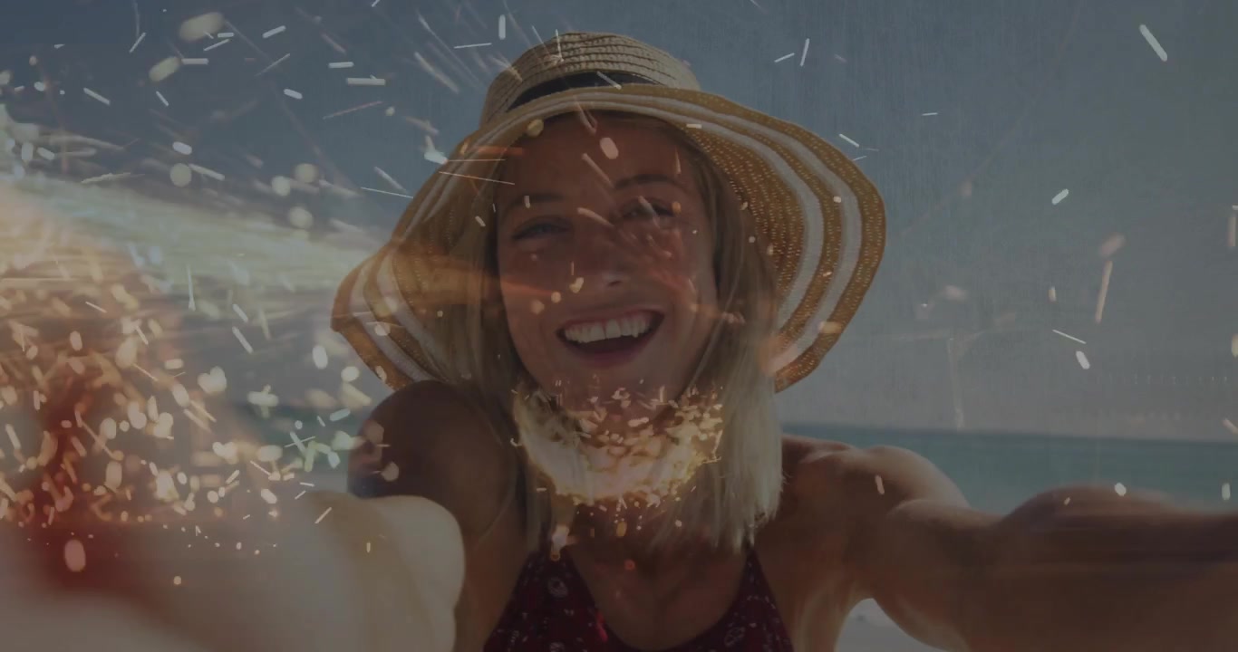 Femme tendant la main vers la caméra sur la plage, jetant du sable et créant un bokeh scintillant pour le marketing.