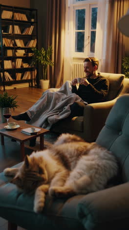 man relaxing with cat in cozy living room