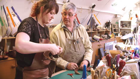 apprentice in bespoke shoemaker stitching together leather