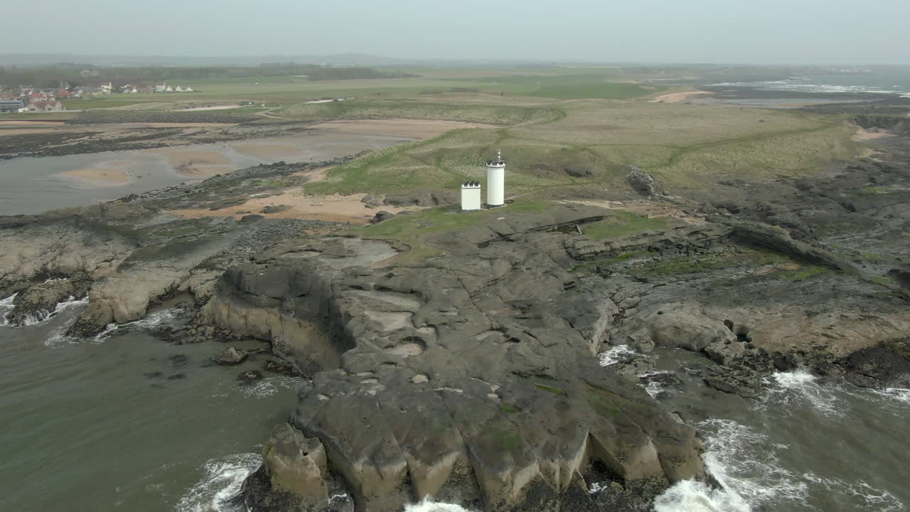 una vista aérea del faro de elie ness y la costa circundante en un día brumoso, fife, escocia