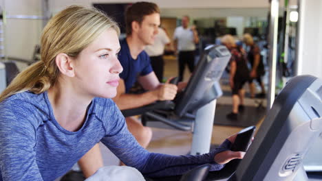 woman exercising on cycling machine in gym