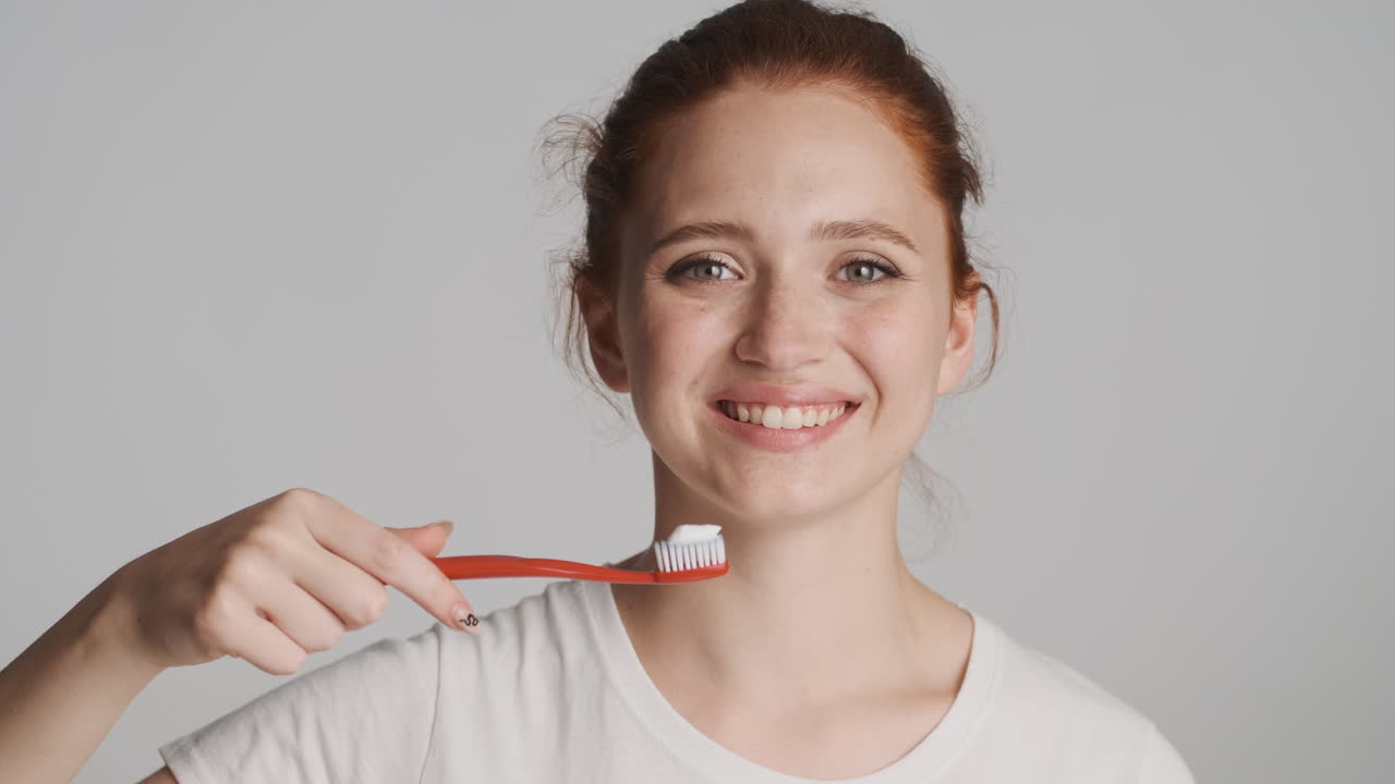 회색 배경에 카메라 앞에 은 머리 소녀.